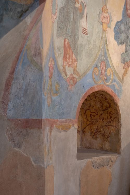 Free Medieval fresco art on an aged church wall featuring intricate designs and an archway. Stock Photo