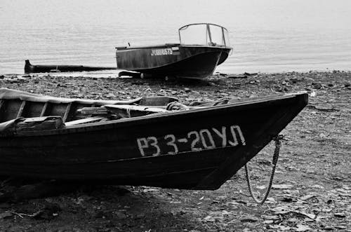 Grayscale Photo of Boast on the Seashore