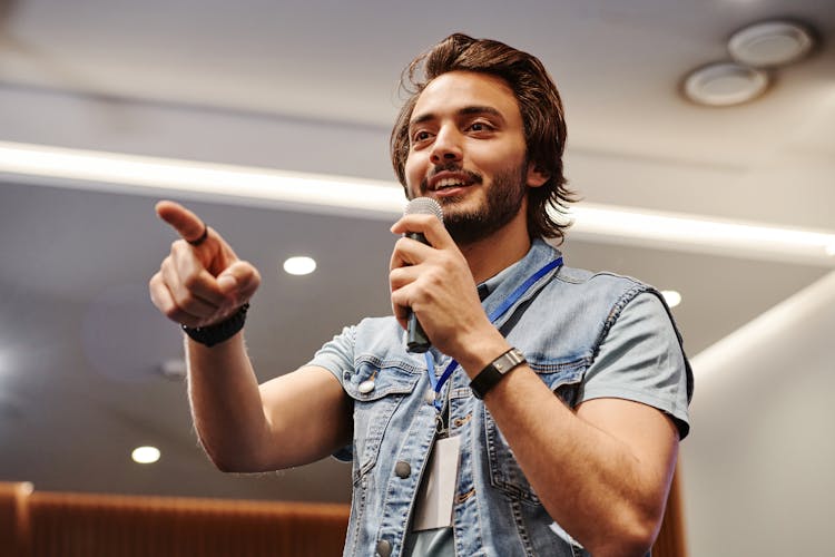 A Young Man Talking With A Microphone