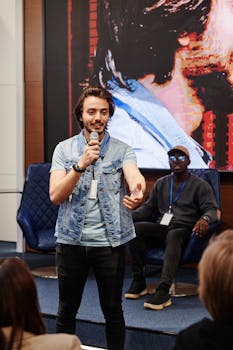 Young male speaker engaging audience at a professional conference indoors.
