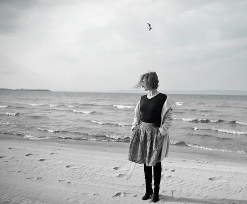 Free Black and White Photo of a Woman Standing on Shore Stock Photo