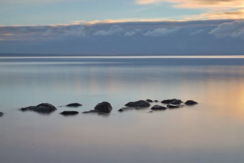 Free Long-exposure shot of Boulders on Body of Sea Stock Photo