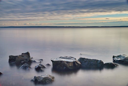 Serene morning view of ocean rocks under a cloudy sky. Perfect for nature lovers.