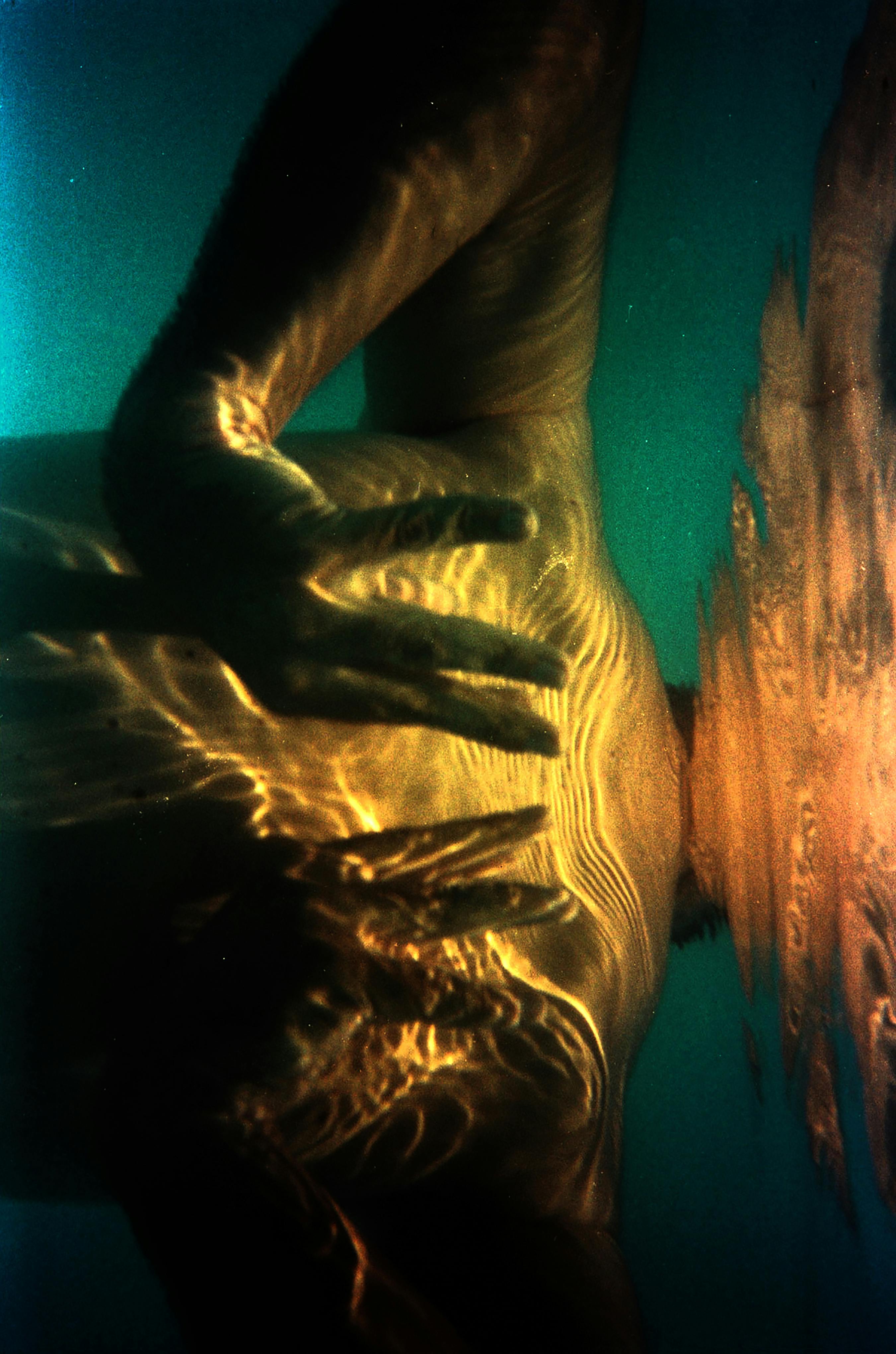 Captivating underwater shot showcasing warm light and hands in artistic composition.