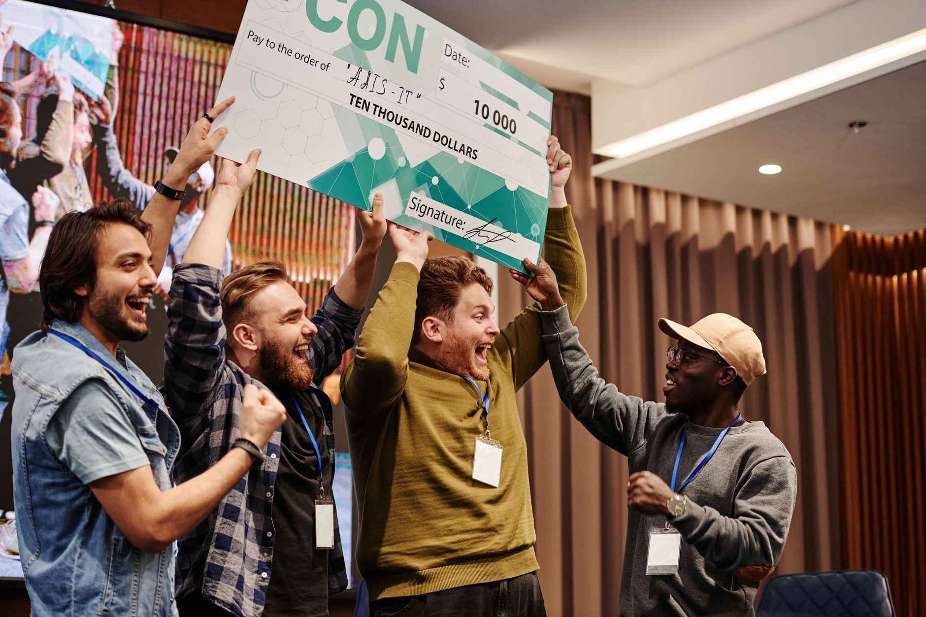 Group of diverse young adults celebrating a $10,000 prize indoors.