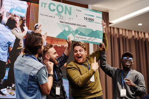 Free Excited business team celebrates winning a ten thousand dollar prize at a tech conference. Stock Photo