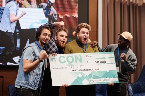 Free Excited group of men celebrate winning a $10,000 prize at an indoor IT conference. Stock Photo