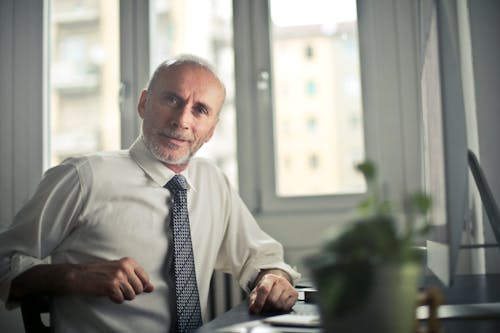 Free Man Sitting on Chair Beside Table Stock Photo