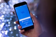 Person Holding Smartphone Displaying Vk Sign in Page