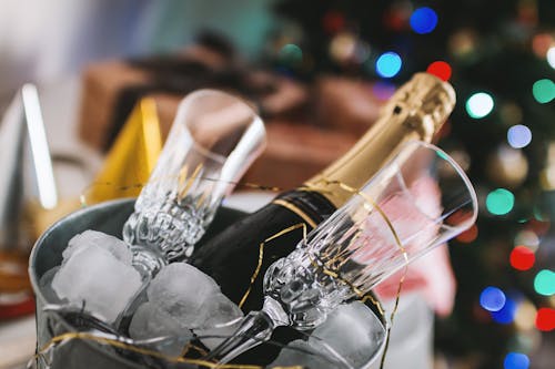 Free Selective Focus Photography of Brown Labeled Bottle and Two Clear Glass Champagne Flutes Stock Photo