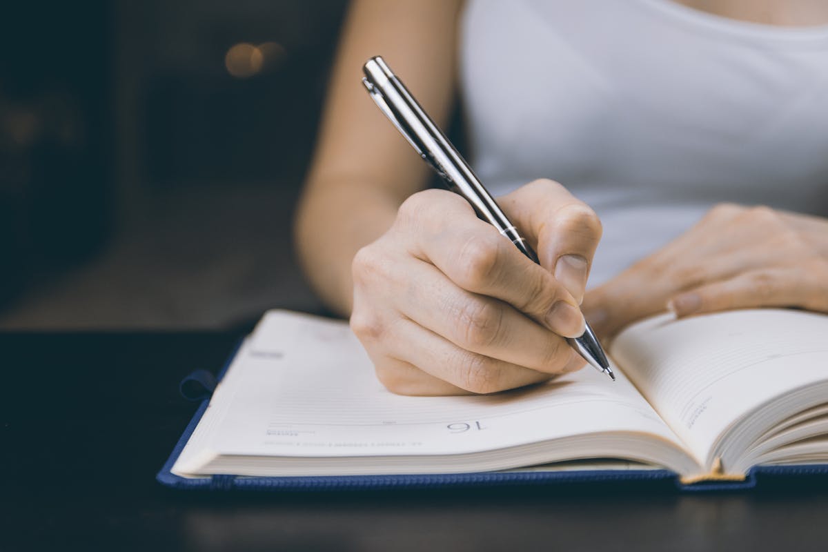 Person writing reflectively in journal during early recovery