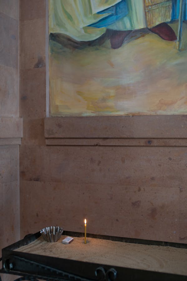 Lighted Candle Planted on a Box of Sand