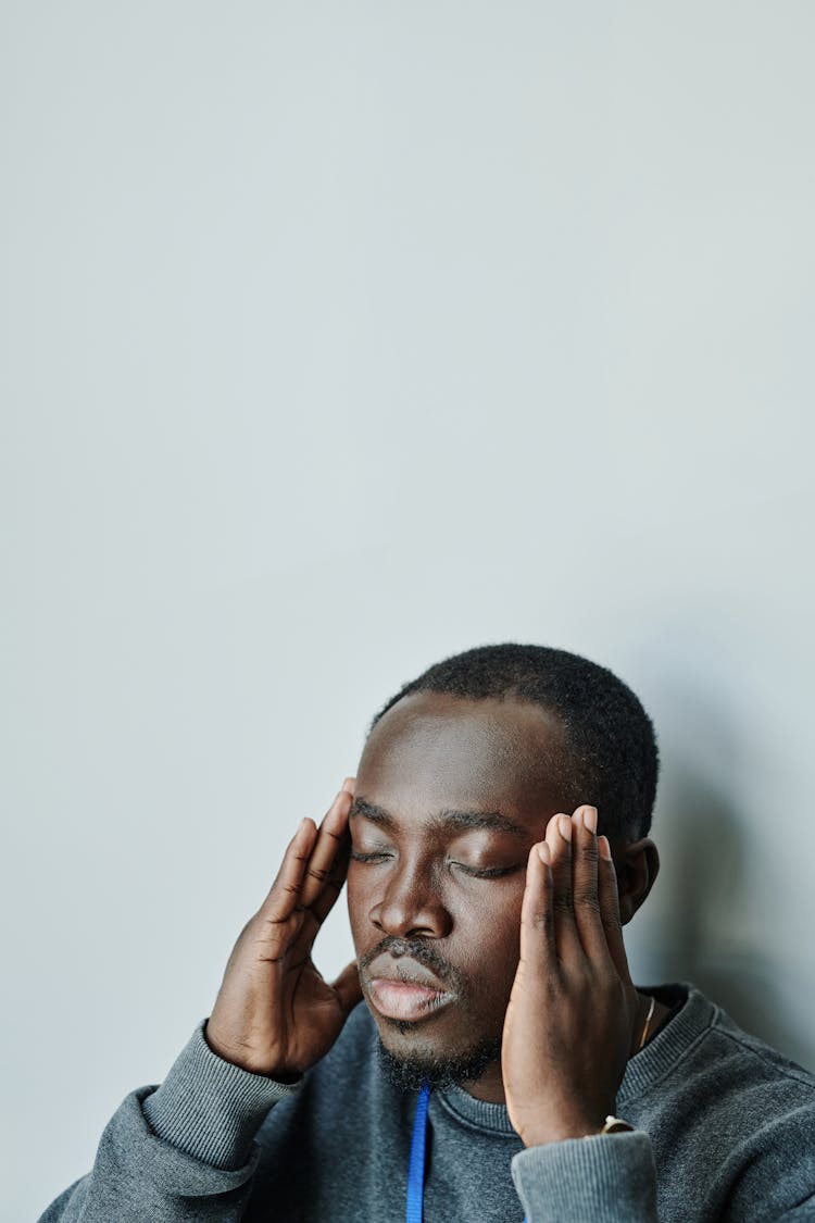 Man In Gray  Long Sleeve Shirt Holding His Head