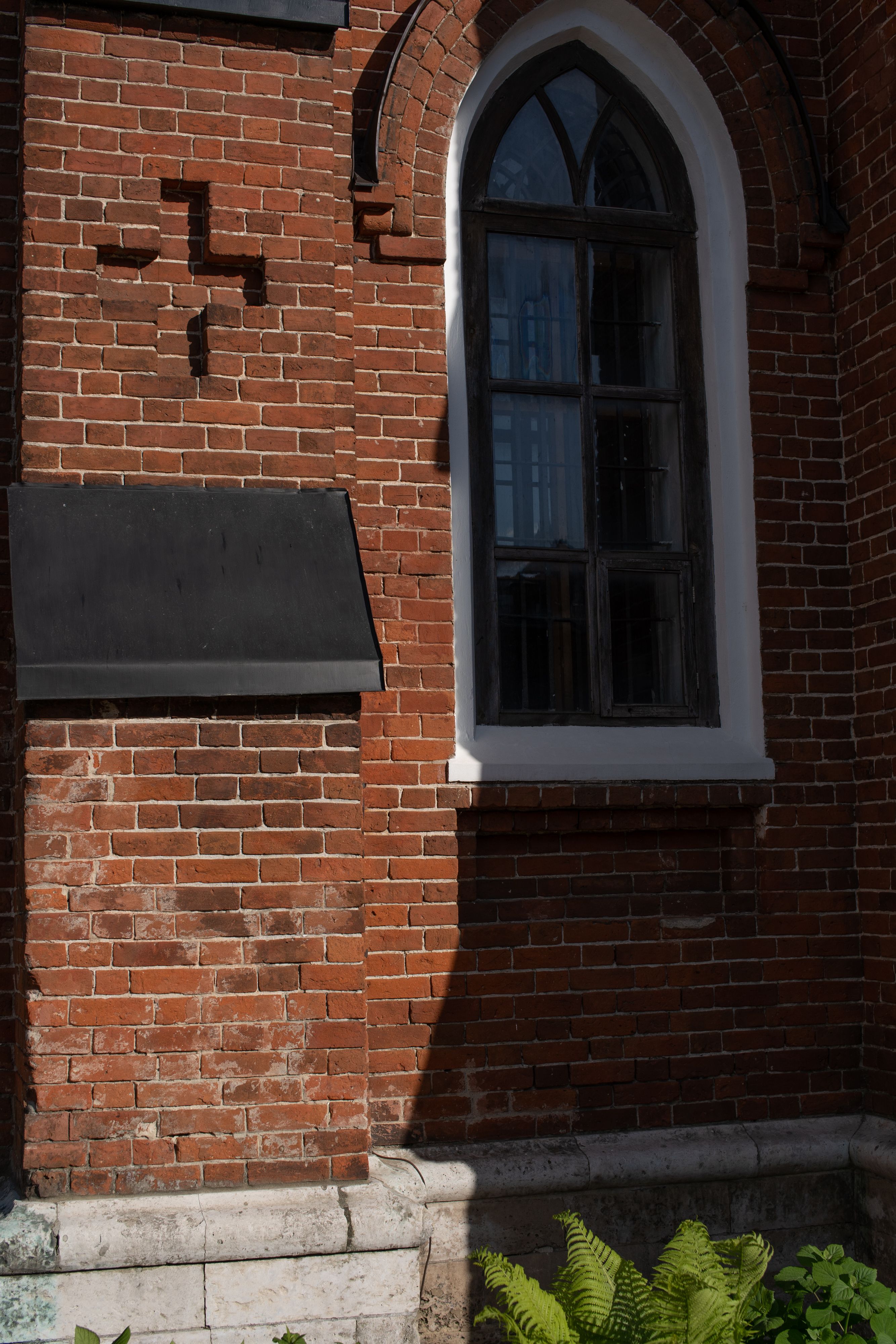 Building Exterior With an Arched Window and Brick Wall · Free Stock Photo