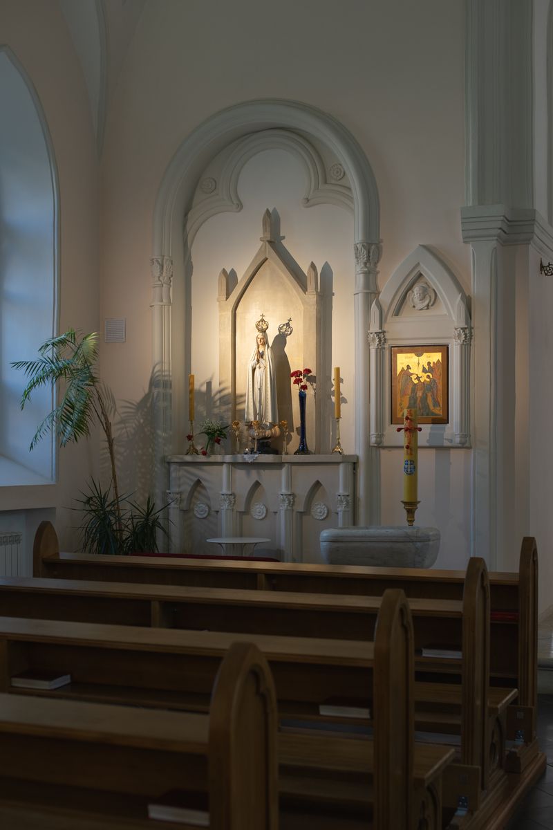 Peaceful church altar with statue and wooden pews