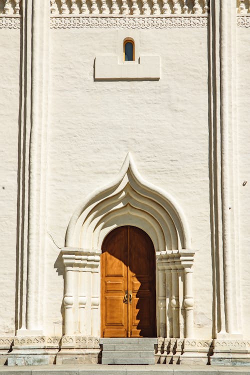 Free Arched Wooden Door On White Wall Stock Photo