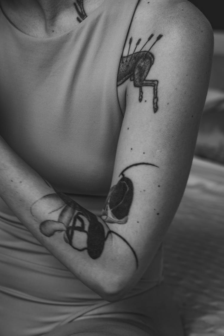 Grayscale Photo Of Woman With Black Tattoo On Her Arm