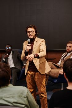 Speaker engages audience during a business conference, fostering interactive discussion.