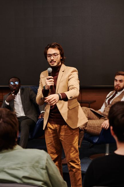 Speaker engages audience during a business conference, fostering interactive discussion. Speaker engages audience during a business conference, fostering interactive discussion.