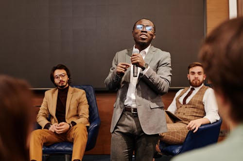 A Man Speaking Holding a Microphone