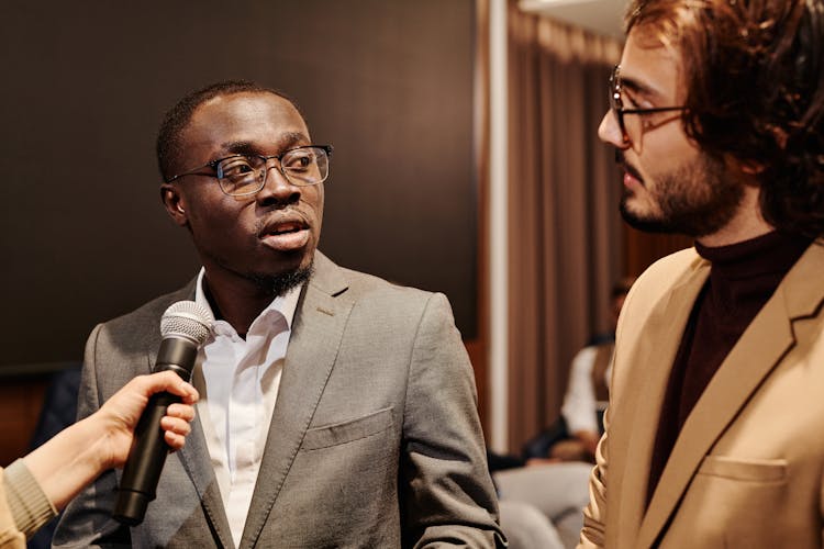 A Man In Corporate Attire Talking At An Interview