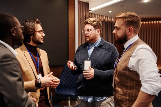 Four members deep in conversation between sessions — photo by Henri Mathieu-Saint-Laurent on Pexels