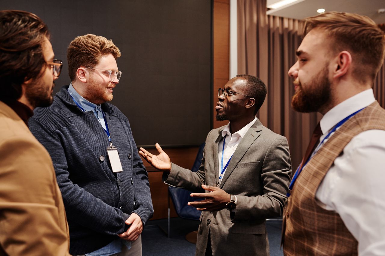 Group of diverse business professionals engaged in a lively discussion indoors