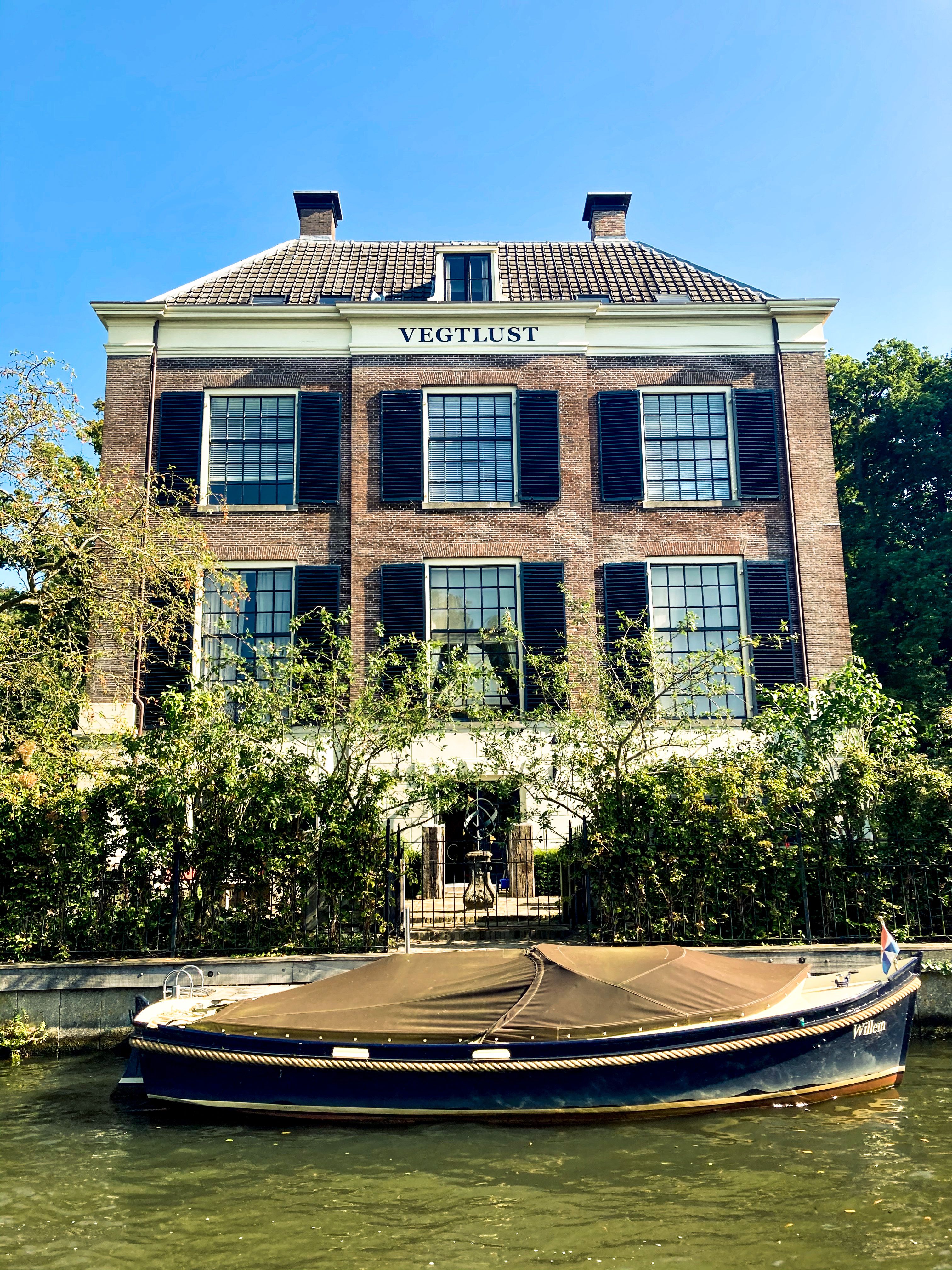 Elegant Dutch architecture with a boat moored on the canal at Vegtlust, Netherlands.