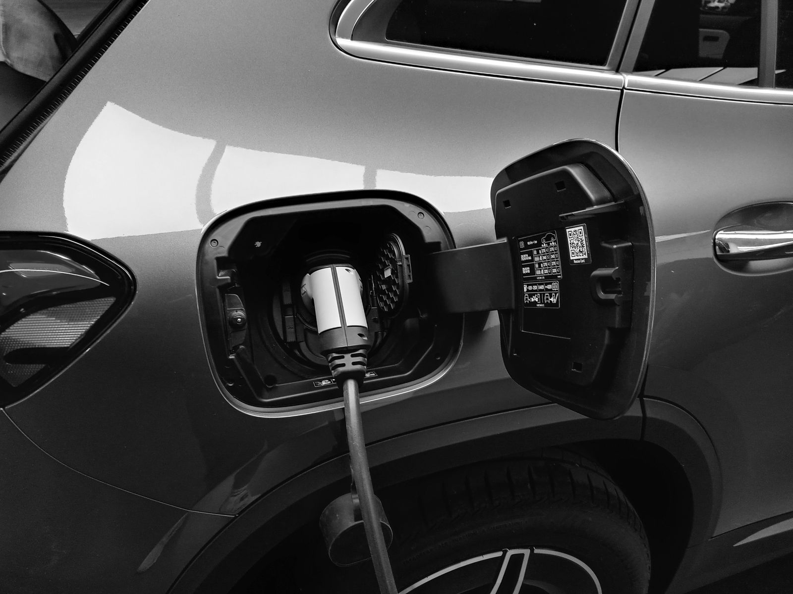 Electric vehicle connected to a charging cable illustrating battery-pack component sourcing programme