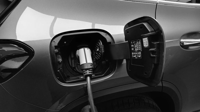 EV charging cable plugged into a car parked in a home garage at night