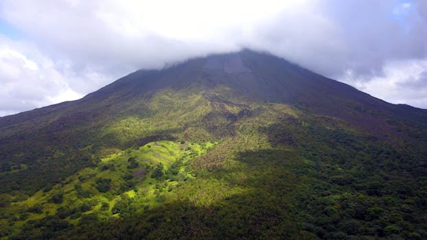 哥斯达黎加的阿雷纳尔火山被郁郁葱葱的绿色植物包围，景色壮丽