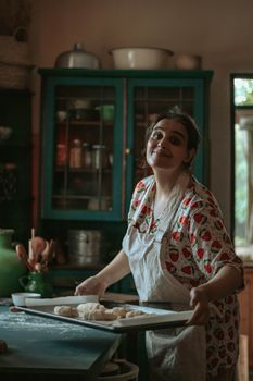 A woman in a vibrant kitchen kneads dough for baking, showcasing homemade culinary art.