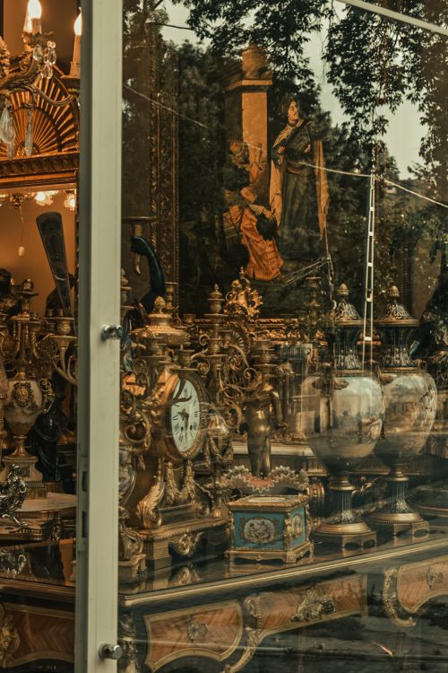 Free A vintage shop window showcasing ornate antiques, clocks, and decorative items. Stock Photo