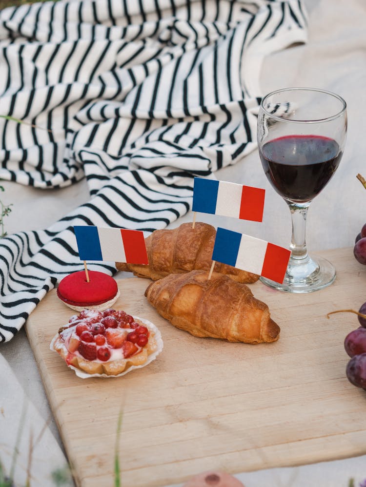 A Glass Of Wine And Food With French Flags