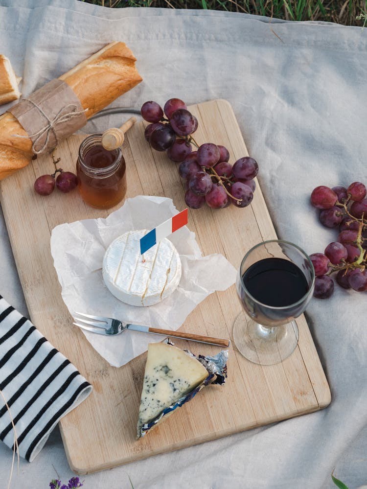 Overhead Shot Of Food And Wine On A Wooden Chopping Board