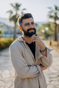 Portrait of smiling man with beard outdoors on a sunny day.