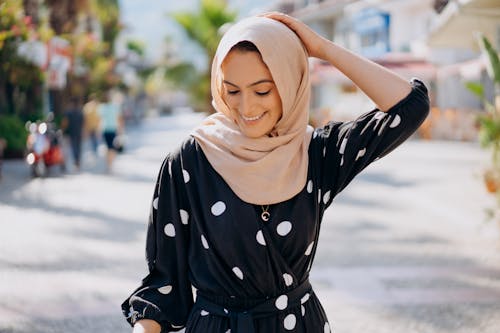 A Smiling Woman Wearing a Hijab and Polka Dots Dress