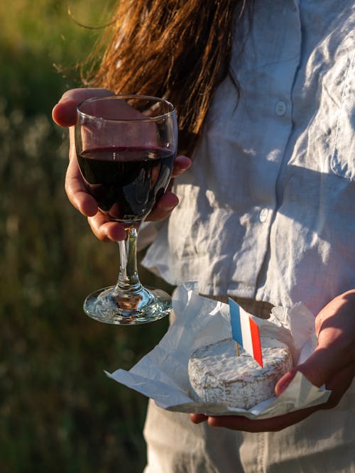 Free Woman Holding a Glass of Red Wine and Camembert Cheese Stock Photo