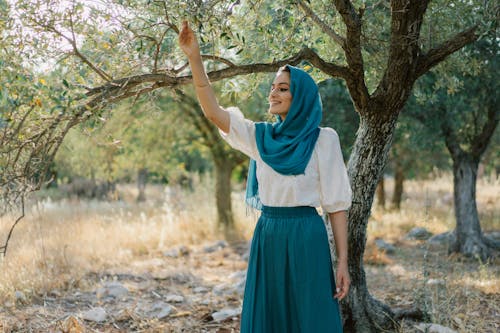 Woman in White Shirt and Blue Skirt Standing Under Tree