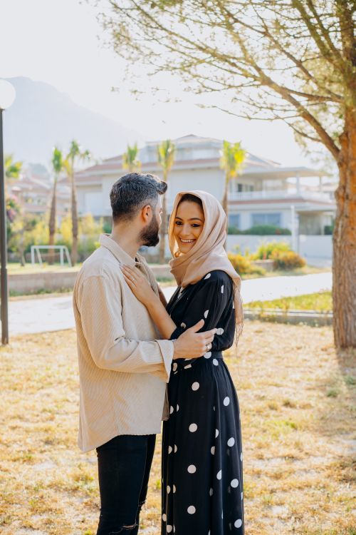 Free A couple shares an affectionate moment outdoors, surrounded by autumn foliage. Stock Photo