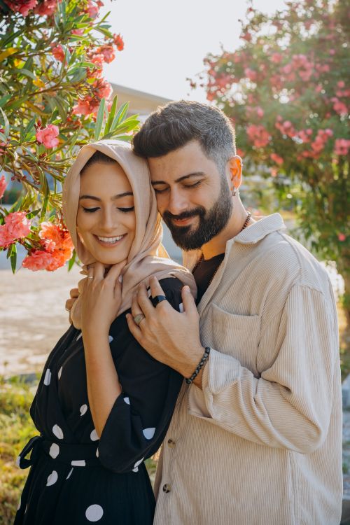 Free Loving couple in traditional attire embracing in a vibrant garden setting. Warm and joyful mood. Stock Photo