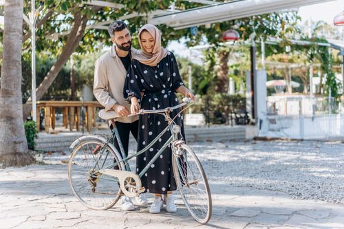 Free A cheerful couple with a vintage bicycle enjoying a sunny day outdoors. Stock Photo