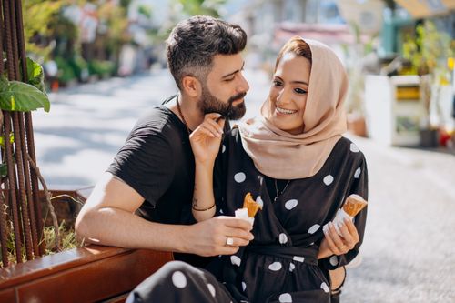 Free A loving couple enjoying dessert outdoors, capturing a moment of affection and happiness. Stock Photo