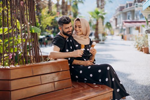 Free A joyful couple sharing ice cream on a sunny day in the park, showing love and affection. Stock Photo