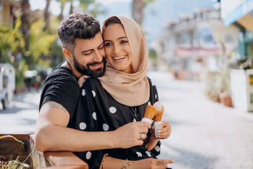Free Happy couple with ice cream cones enjoying a sunny day outdoors. Stock Photo
