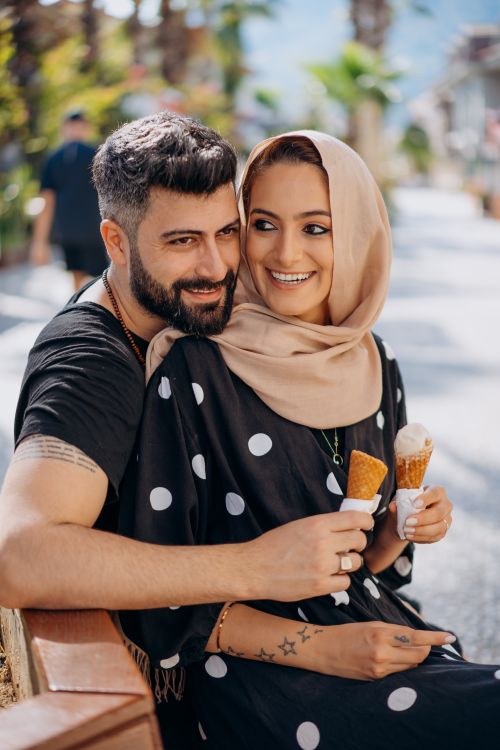 Free Romantic couple savoring ice creams together outdoors on a sunny day. Stock Photo