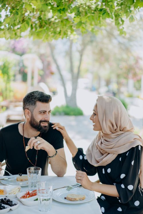 Free A Muslim couple enjoying a romantic outdoor lunch together under a vibrant tree. Stock Photo