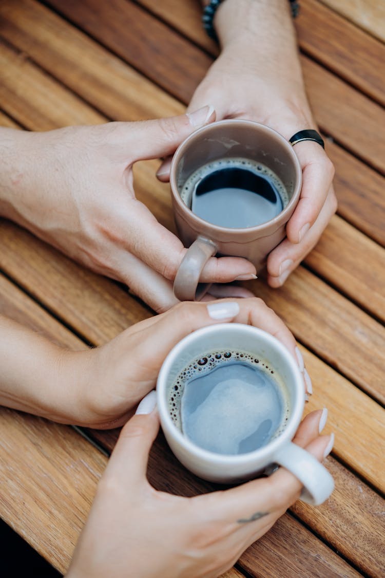 People Holding Mugs