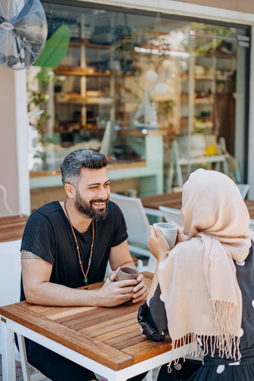 Free Man Having a Date with a Woman Wearing Head Scarf Stock Photo