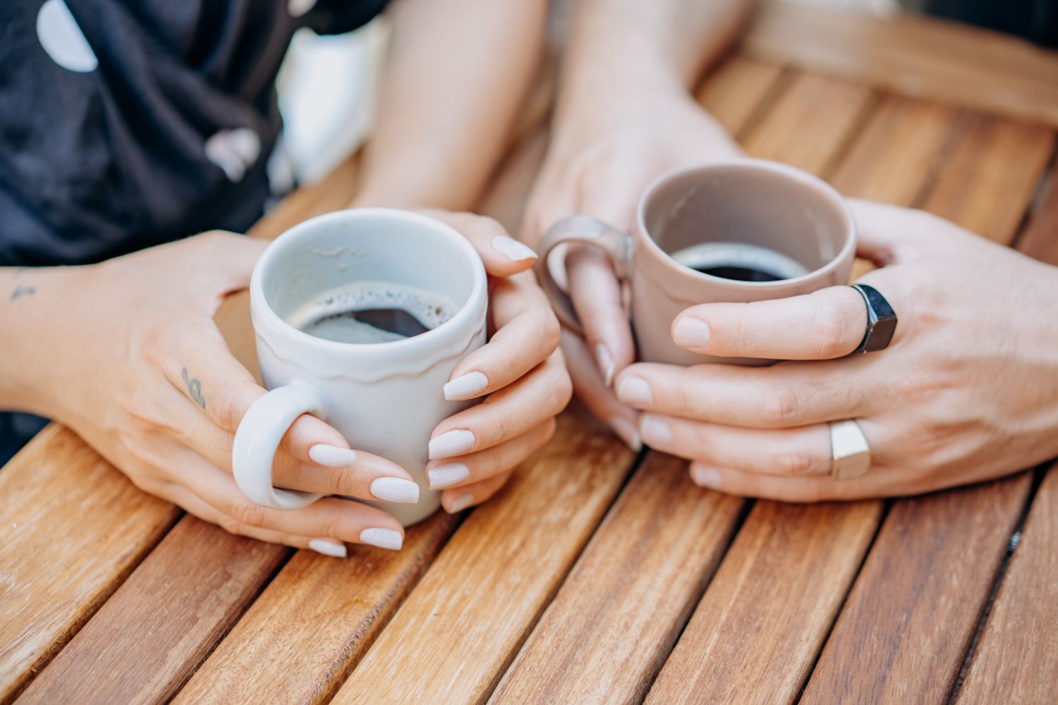 Deux mains tenant une tasse chaude, dans une lumière douce — moment calme et rassurant